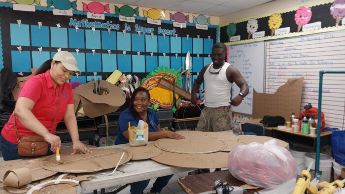 Betty K Agencies team members assisting students with Junior Junkanoo costume materials